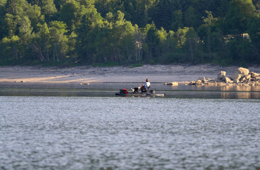 unrecognizable fisher on the fishing sup boards on the lake