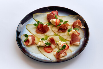 A Gourmet Presentation of Delicate Prosciutto, Fresh Strawberries, and Creamy Cheese on a Plate...