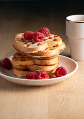 Stack of waffles with fresh raspberries