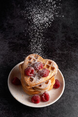 Powdered sugar falling on a stack of waffles