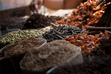 Aromatic mounds of dried spices and herbs—cardamom, seeds, and roots—are captured in sharp...