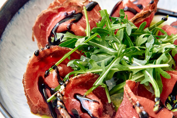 Deliciously Plated Beef Carpaccio with Arugula Garnish and Balsamic Drizzle Showcasing Culinary Elegance and Flavorful Ingredients