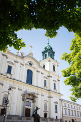 Historic Holy Cross church building in Warsaw, Poland surrounded by greenery on a sunny day