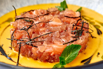 Deliciously Plated Salmon Tartare with Fresh Herbs and Light Sauce Served on an Elegant Dish, Perfect for Gourmet Dining Experience