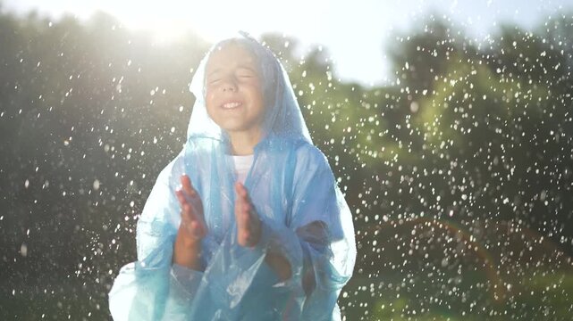 Joyful kid in raincoat splashing in puddle. Happy kid enjoying rain playing in puddles while wearing raincoat. Kid laughter echoes as rain falls. Raincoat clad kid embraces rainy day fun with puddles.