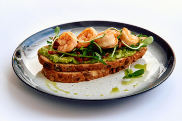 A Delicious Open-Faced Toast with Succulent Shrimp, Fresh Greens, and Creamy Avocado Spread on...