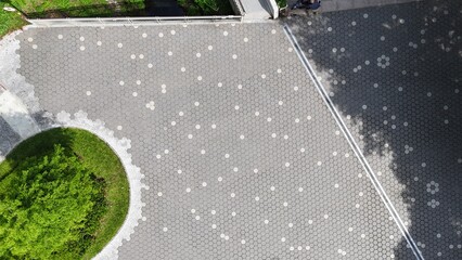 Modern concrete paving stones with decorative pattern and green island