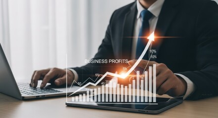 Business analytics professional analyzing financial data on laptop and tablet