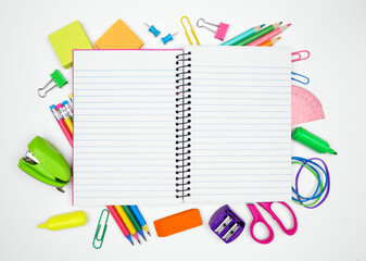 Blank coil notebook with school supplies frame over a white background. Back to school concept....