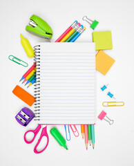 Blank coil notebook with school supplies frame against a white background. Back to school concept....