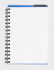Open coil notebook with blank paper page over a white background. Copy space.