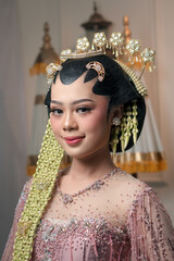 Smiling Asian bride in traditional Javanese kebaya, wearing intricate golden hairpieces, jasmine...