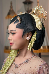 Graceful Asian bride in traditional Javanese kebaya, adorned with jasmine garlands and golden hair...