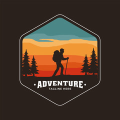 Fototapeta premium Adventure badge with hiker silhouette, pine trees, and sunset mountain landscape in hexagon shape.
