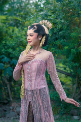 Elegant Asian woman in traditional Javanese bridal kebaya, adorned with luxurious golden...