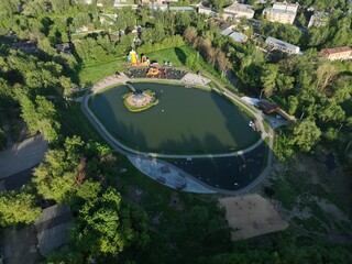 An aerial view showcasing a pond within or near the urban area of Kirzhach city, with surrounding landscape elements
