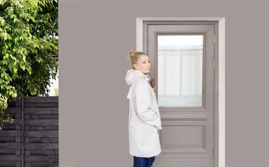 Woman opening doors of house (hotel, store)