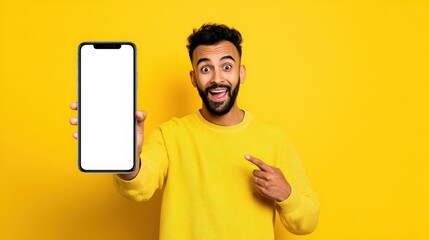Happy excited young indian man showing smartphone pointing at big mockup white blank phone template screen isolated on yellow background presenting cellphone mobile offer application ads concept., no