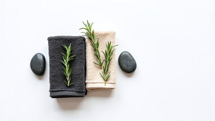 Fresh rosemary sprigs on a wooden block surrounded by stones.