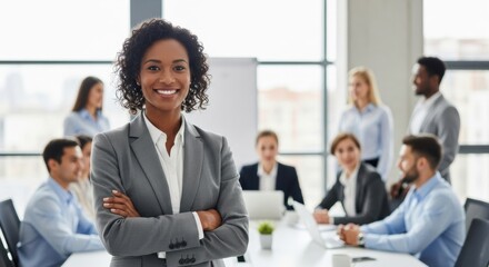 Confident African American female leader smiling with her diverse team in a meeting room. Successful black businesswoman leading a corporate presentation.