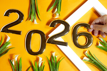 Bright Golden Numerals Arranged Representing Year 2026 with Greenery