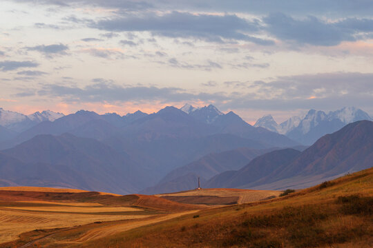 Vibrant summer mountains landscape - meadows in highlands with a small tower in foreground