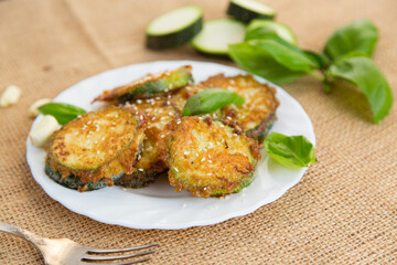 Summer vegetable appetizer of fried zucchini and sesame seeds on a rustic table