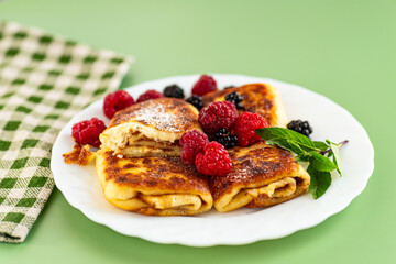 Soft cheese pancakes with sugar and raspberry topping