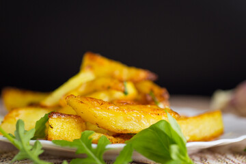 Delicious potatoes with a crispy crust for dinner on a black background
