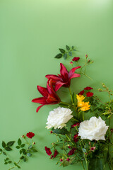 Lush red lilies with red roses and white on green background