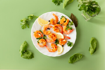 Fried red shrimps in a plate isolated on green