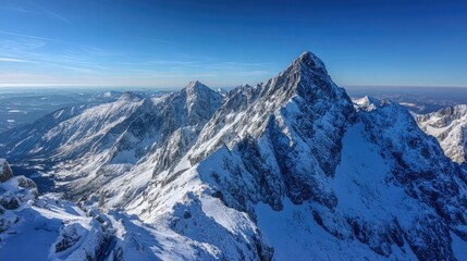 Obraz premium Majestic, snow-covered mountain peaks rise against a clear blue sky, embodying serene alpine beauty.