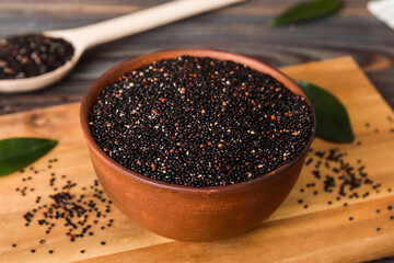 quinoa seeds in bowl and spoon on colored background. Healthy kinwa in small bowl. Healthy superfood