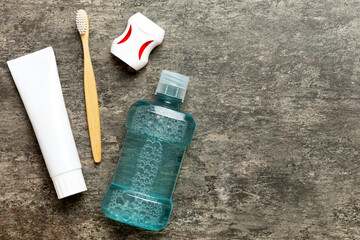 Mouthwash and other oral hygiene products on colored table top view with copy space. Flat lay....