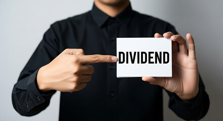 A man holds a card with the word dividend written on it in front of him
