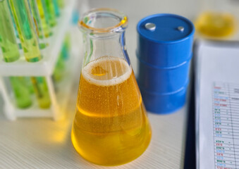 Liquid experiment in a laboratory with a yellow solution and scientific equipment visible