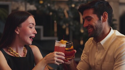 Smiling beautiful woman making a toast with Paloma cocktail to smart couple in Old fashioned savoring tasty enjoy drinking in lively conversation at bar refreshing special nightclub party. Vinosity.