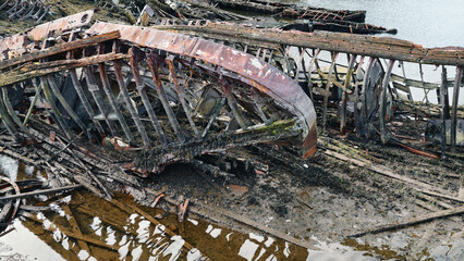 old abandoned sunken ship in the water at the ship cemetery wood pattern