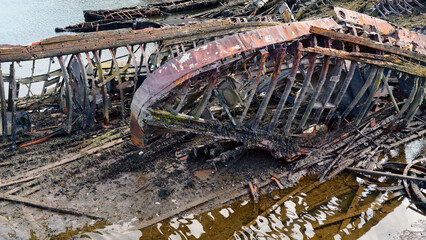 old abandoned sunken ship in the water at the ship cemetery wood pattern