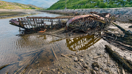 old abandoned sunken ship in the water at the ship cemetery wood pattern