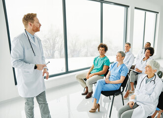 Portrait of a young doctor teaching on a seminar in a board room or during an educational class at convention center