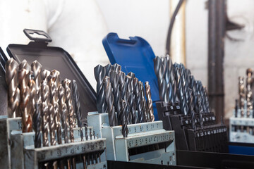 Sets of drills on a table in a workshop.
