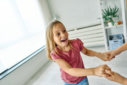 Portret of brother and sister having fun dancing together at home