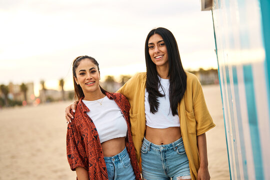 Fototapeta Portrait of two beautiful cheerful young women resting  on the beach. Laughing girlfriends in the sea side having fun