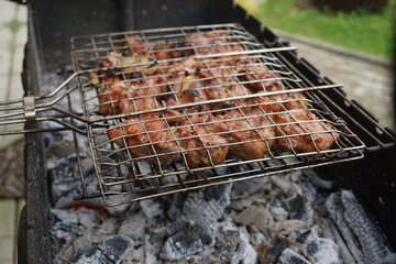 Juicy pork shish kebab sizzling on the grill over a barbecue in a country house, smoky barbecue with mouth-watering meat