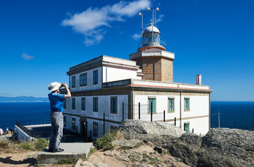 Visitor takes photos at the Finisterre Lighthouse
Translation: 