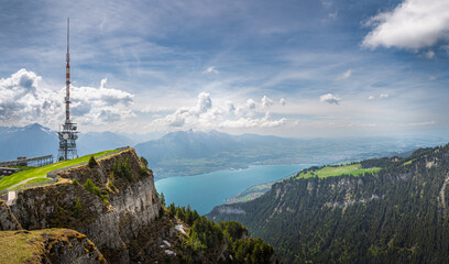 Niederhorn mountain summit with the antenna tower on it with Bernese Alps and lake Thun in the...