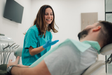 Female dentist explaining treatment to patient in modern clinic