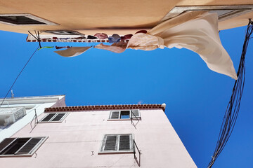 Laundry Day Clotheslines and Buildings Against a Bright Blue Sky