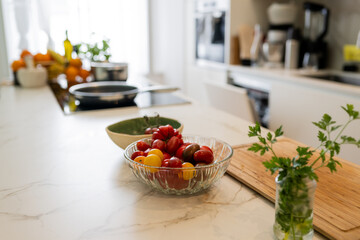Fresh Vegetables on Marble Counter in Modern Kitchen with Natural Light and Cooking Tools